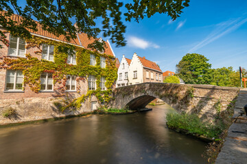 Fototapeta premium Traditional stone bridge and medieval architecture near Bruges canal. Belgium