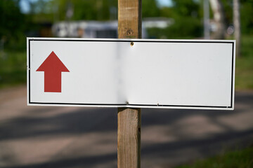 Signpost with directional arrow on a path at a campsite