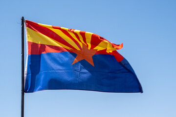 Arizona State flag, waving in the wind against blue sky