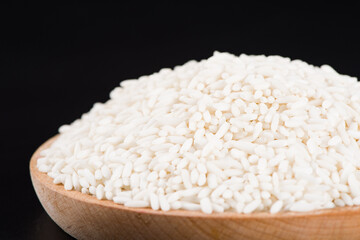 Raw organic white rice on black background, glutinous rice or sticky rice close up
