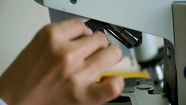 Scientist switching lens of microscope from Laboratory micro science medicine research chemistry equipment scope biotechnology. Close-up shot of microscope with metal lens at laboratory.