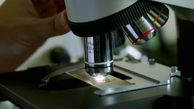 Scientist switching lens of microscope from Laboratory micro science medicine research chemistry equipment scope biotechnology. Close-up shot of microscope with metal lens at laboratory.