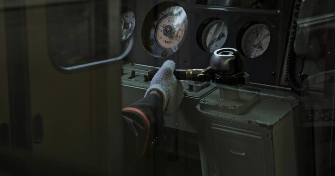 Hands of the train driver commanding buttons to drive train. Shot in slow motion 4k