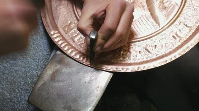 Traditional tinsmith work. Copper smith makes embossing artifacts from copper.  copper engraving. souvenirs Shooting close-up Coppersmith work. 4K.