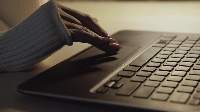 Virtual searching. Internet technology. Laptop working. Digital lifestyle. Unrecognizable woman scrolling portable computer touch pad light lamp dark shadow.