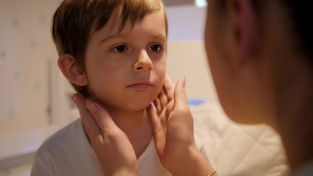 Little boy showing soring throat to his mother. Concept of children illness, disease and parent care