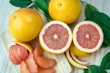 Fresh Grapefruit with leaf on wooden background, Fresh Yellow pomelo with slice on wooden Background.