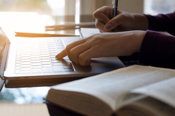 person writing on a notebook, work on laptop computer