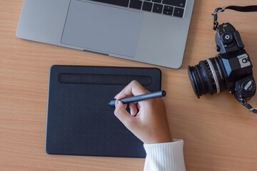 graphic designer work on digital tablet by using electronic pen with laptop computer and camera on...
