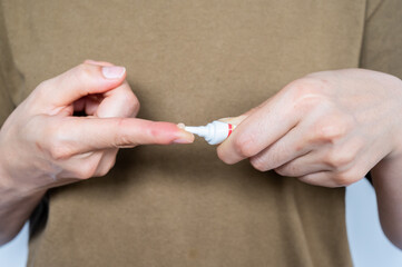 Close up of woman squeezes out cream from cosmetic tube.