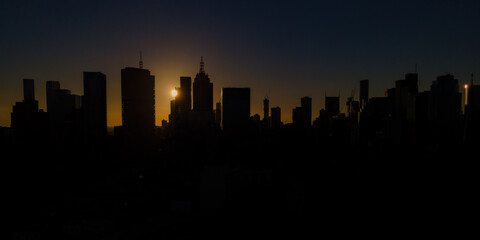 Naklejka premium Melbourne city skyline silhouetted by a dramatic sunset