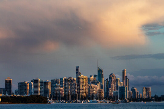 city skyline under storm clouds at sunset