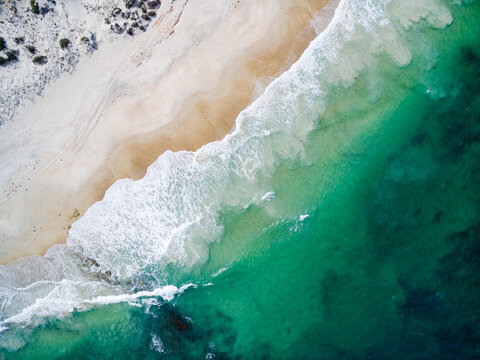 aerial view of waves washing up onto a beach