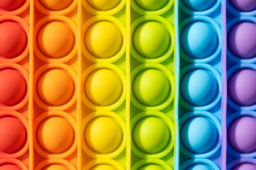Pop it antistress close-up. Modern antistress toy. Background from rainbow toys.