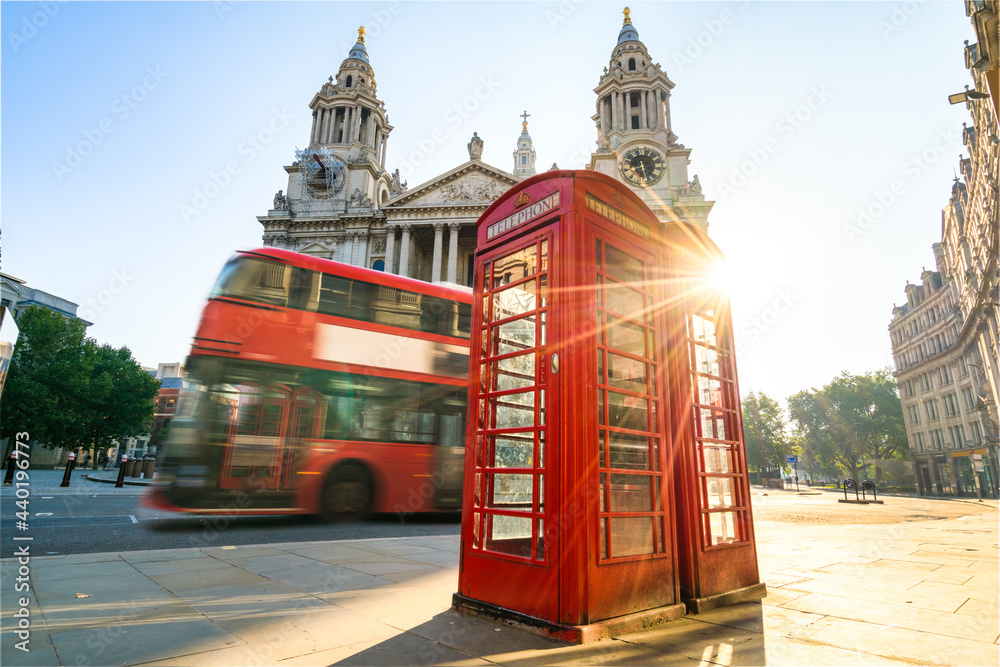 Canvas Prints red telephone booth at sunrise with blurry bus passing by near st pauls cathedral in london