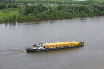 Nizhnekamsk, Tatarstan, Russia - 06.16.2021: A cargo ship loaded with lumber passes along the Kama...