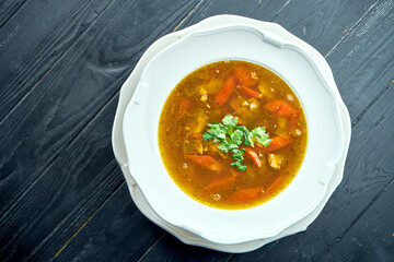 Close up view Chorba soup or stew with beef, herbs and hot pepper in white bowl on wooden background, Traditional turkish cuisine