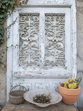 Vertical Shot Of An Old Decorative Antique Door With Basket And Flower Pots Bel