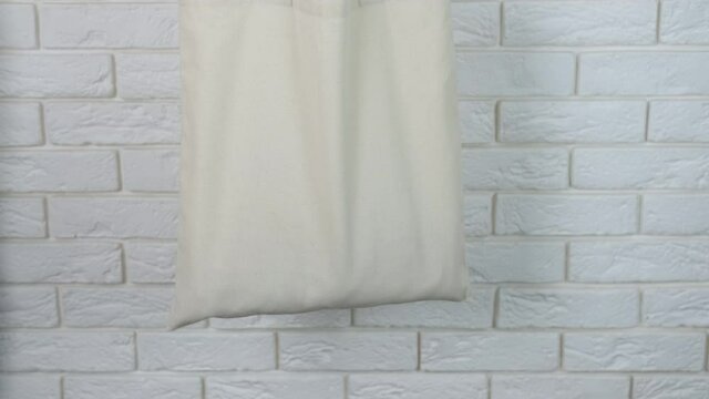 Delivery in eco bag. A view of a female hand with grocery eco shopper in the room.