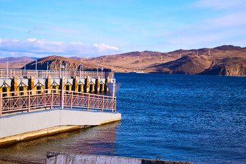 An old wooden pier on a sunny day with blue water and sky