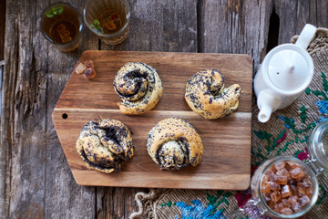 Fototapeta na wymiar Poppy seed buns. Side view, wooden background. Herbal tea.