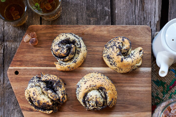 Poppy seed buns. Side view, wooden background. Herbal tea.