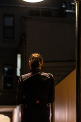 Fototapeta na wymiar lady from behind walking down a dark alley in the city