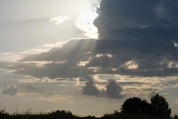 Landscape, Dark Sky, Sunset. The sun went behind clouds, rays of light.