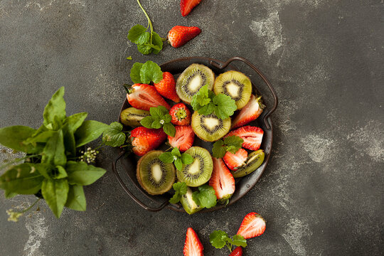 bright and fresh strawberries and kiwi on a dark background