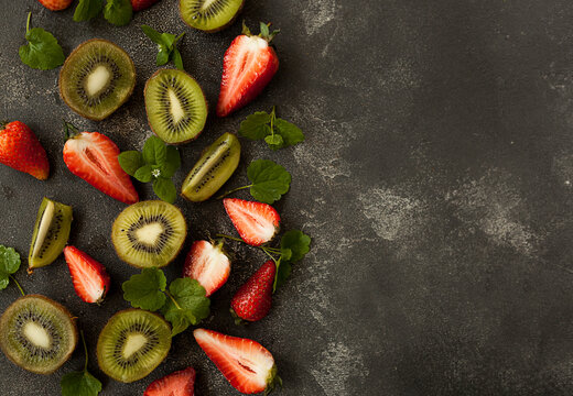 bright and fresh strawberries and kiwi on a dark background
