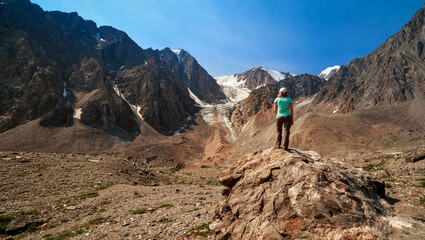 Obraz premium Photo of a tourist girl in the Altai Mountains. In the background is the Bolshoy Aktru Glacier, one of the oldest glaciers in the Altai Mountains.