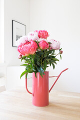 Bouquet of pink peonies in a matching pink watering can