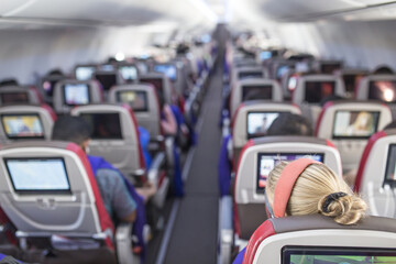 Passengers traveling by a new jet plane, shot from the inside of an airplane