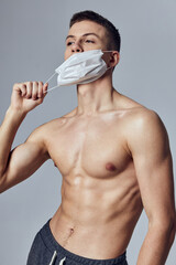 athletic man with pumped up abs medical mask health safety workout