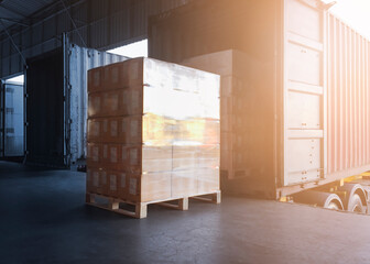 Stacked of Package Boxes Load with Cargo Container. Trailer Truck Parked Loading at Dock Warehouse. Delivery Service. Shipping Warehouse Logistics. Cargo Shipment. Freight Truck Transportation.