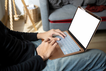Casual man sitting on couch and surfing internet with laptop.
