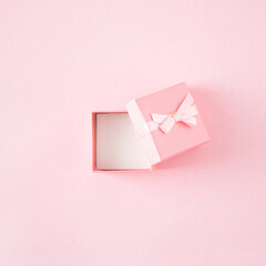 Pink open gift box on pastel pink background