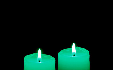 Glowing a pair of mint green candles in the dark with copy space