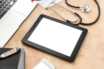 Tablet computer with accessories of doctor on color background