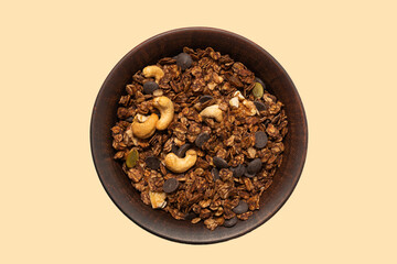 Chocolate granola cereal with nuts in a bowl background.