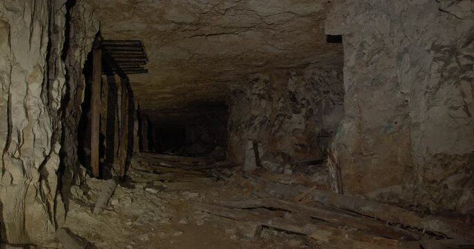 Walk inside a dark scary horrible underground cave. The mine looks like a dungeon with monsters or ghosts living in it.
