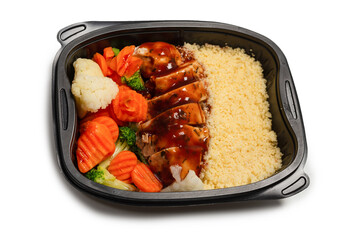 Ready food in a container. Stewed chicken in teriyaki sauce, stewed carrot, cabbage and porridge.