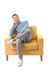 Fototapeta premium Young man sitting in armchair on white background