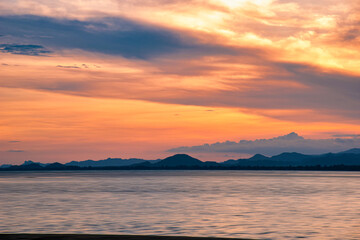 Beautiful cloudscape and dramatic sunset over mountain and sea.