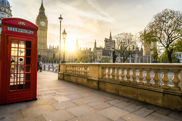 Red telephone booth and Big Ben at sunrise in London. England