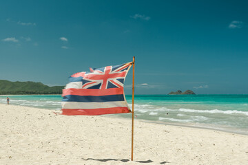 Hawaii state flag on the beach. Waimanalo Bay State Recreation Park, Oahu, Hawaii. The longest stretch of sandy shoreline on Oahu