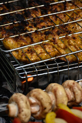 Chicken meat barbecue and mushrooms cooking on fire. 
