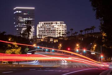Twilight evening view of traffic streaming by the downtown skyline of Irvine, California, USA.