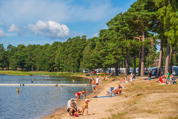 Bathing lake with a sandy beach and sunbathing people