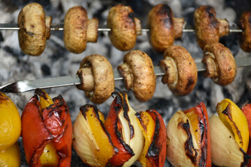 Yummy grilled vegetables: mushrooms, onions and red bell peppers. Tasty vegetarian barbecue.